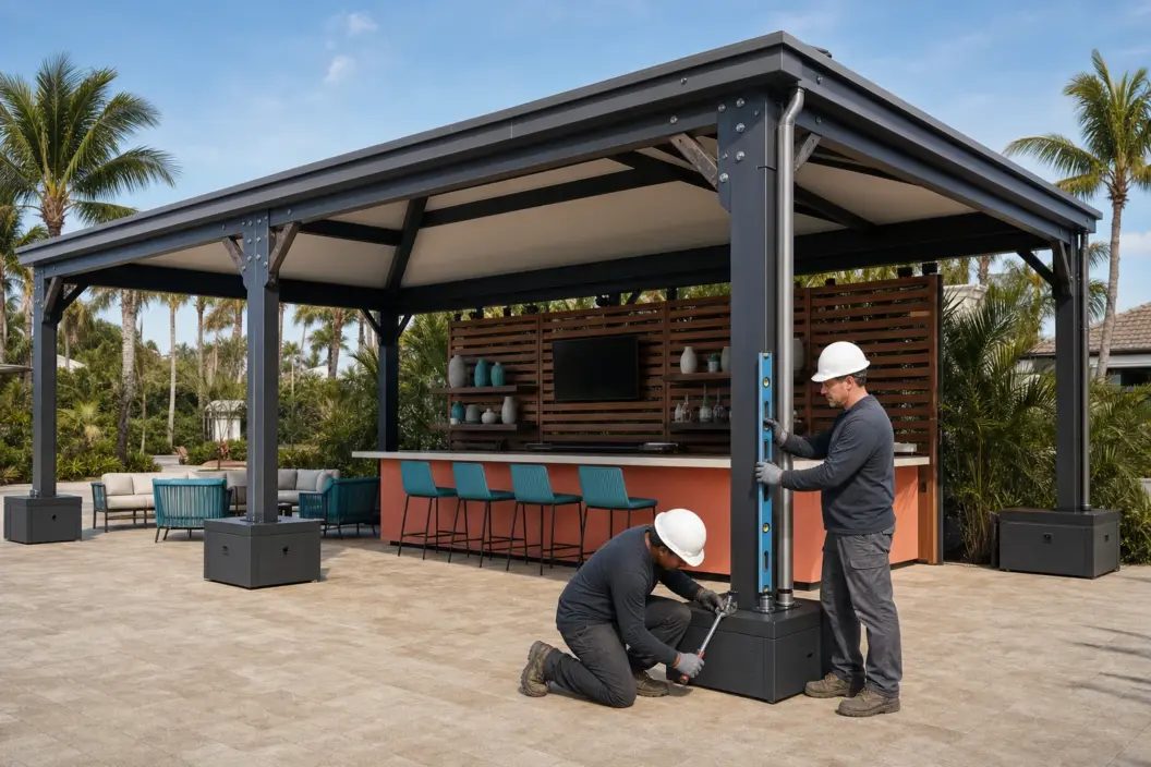 Two installers level and torque-check a ballasted custom event pavilion with bar seating in Florida.