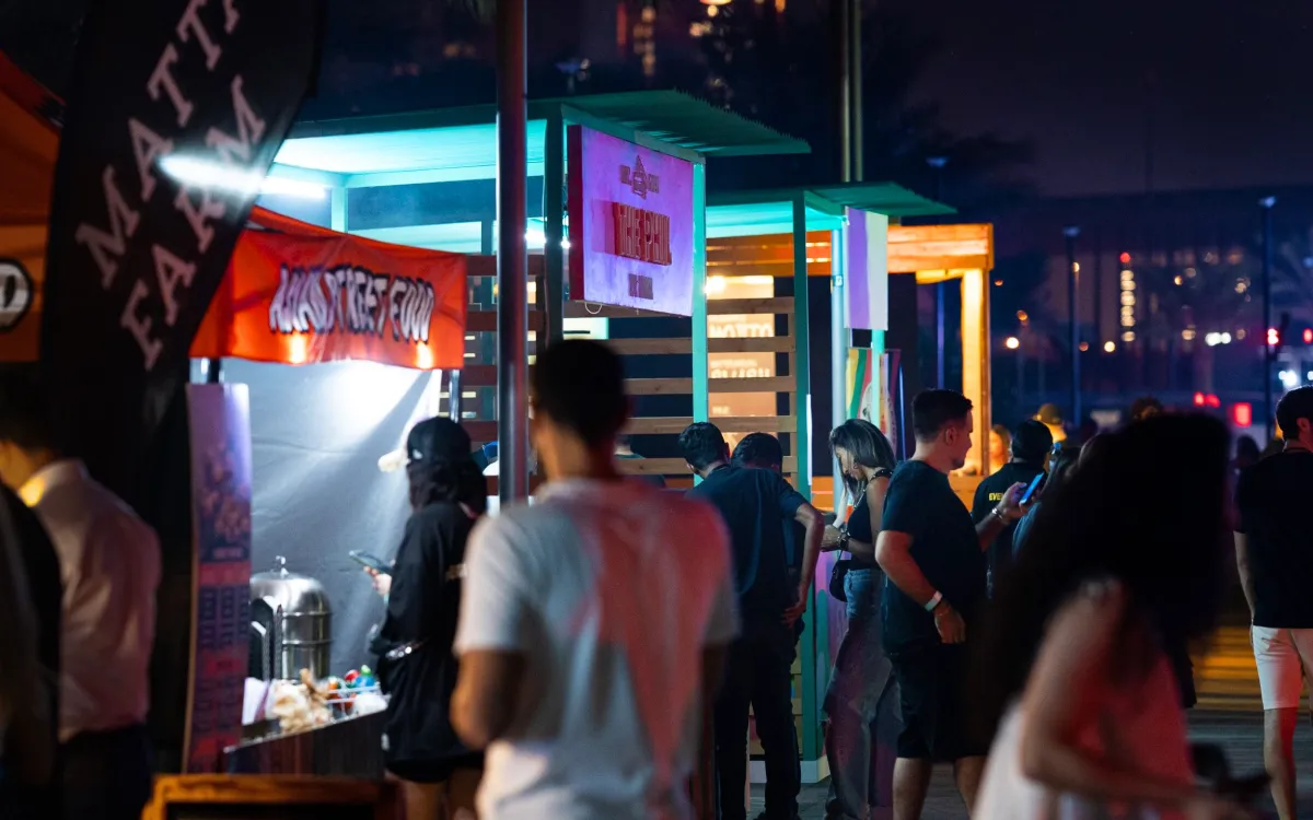 Guests queue at sustainably built food stalls during the night festival