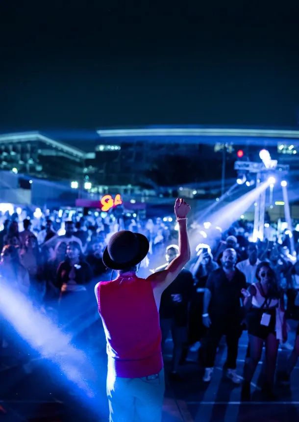 Performer raises an arm toward the nighttime festival crowd