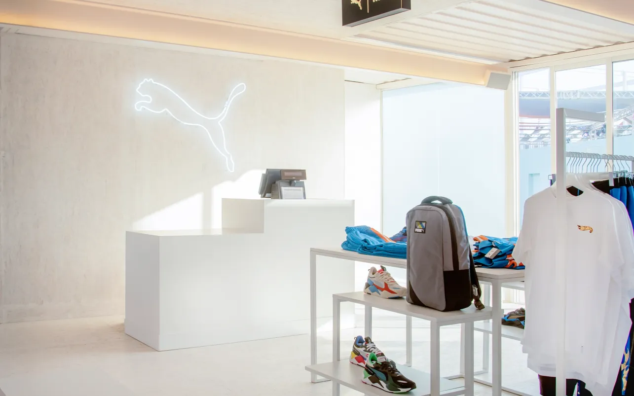Minimalist Puma retail counter with apparel and footwear displays