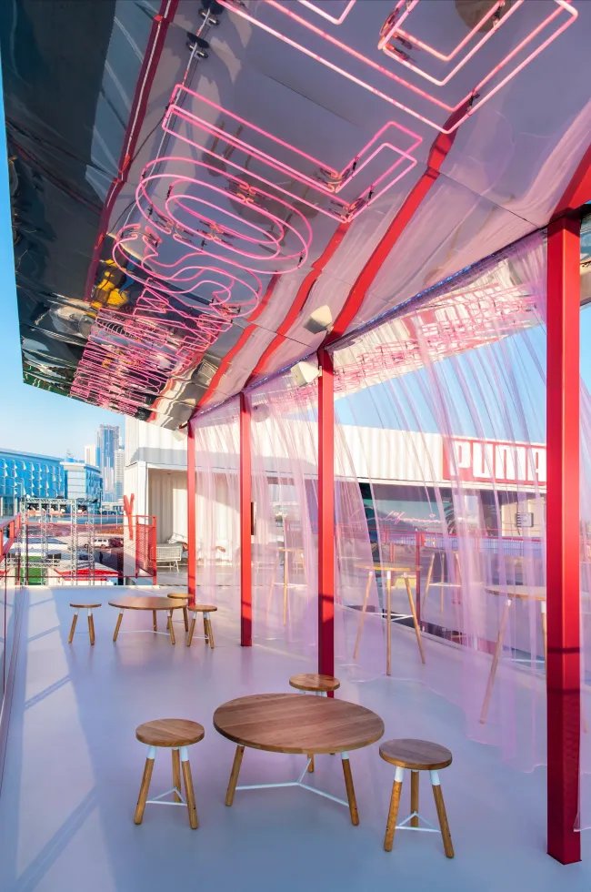 Neon-lit lounge inside the Puma shipping-container pavilion