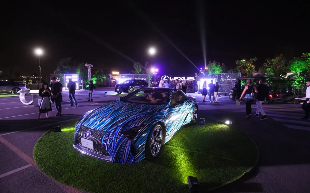 Illuminated Lexus display car on a circular grass platform at night