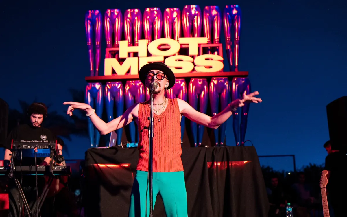 Singer performs before the illuminated Hot Mess stage sign