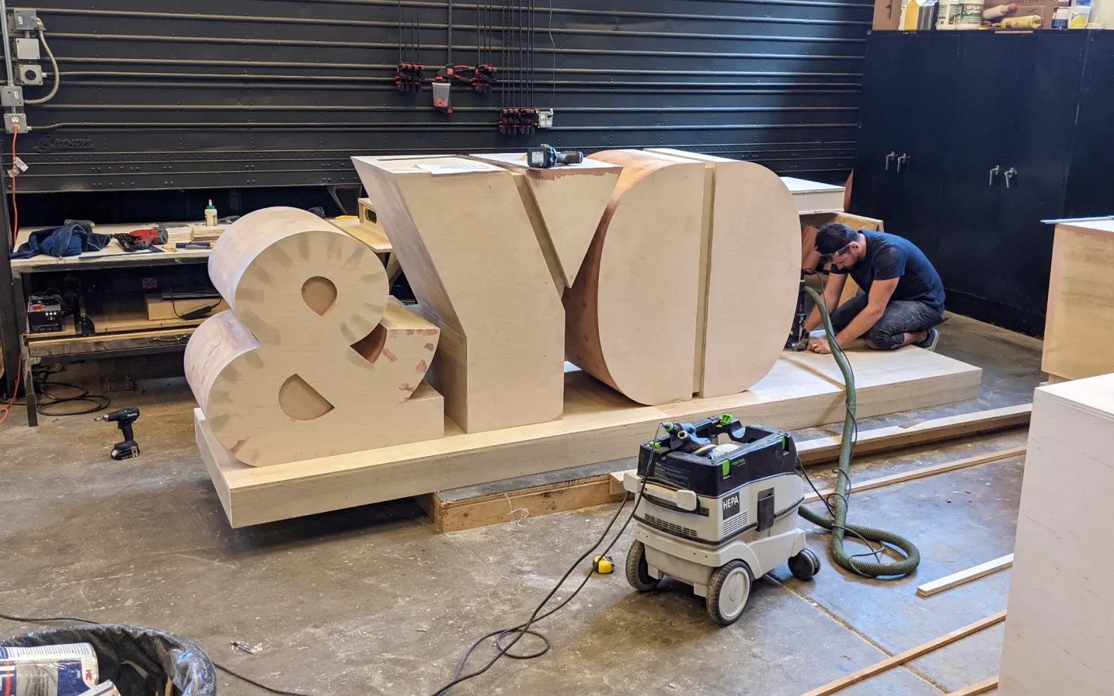 Oversized wooden letters under construction in the fabrication workshop