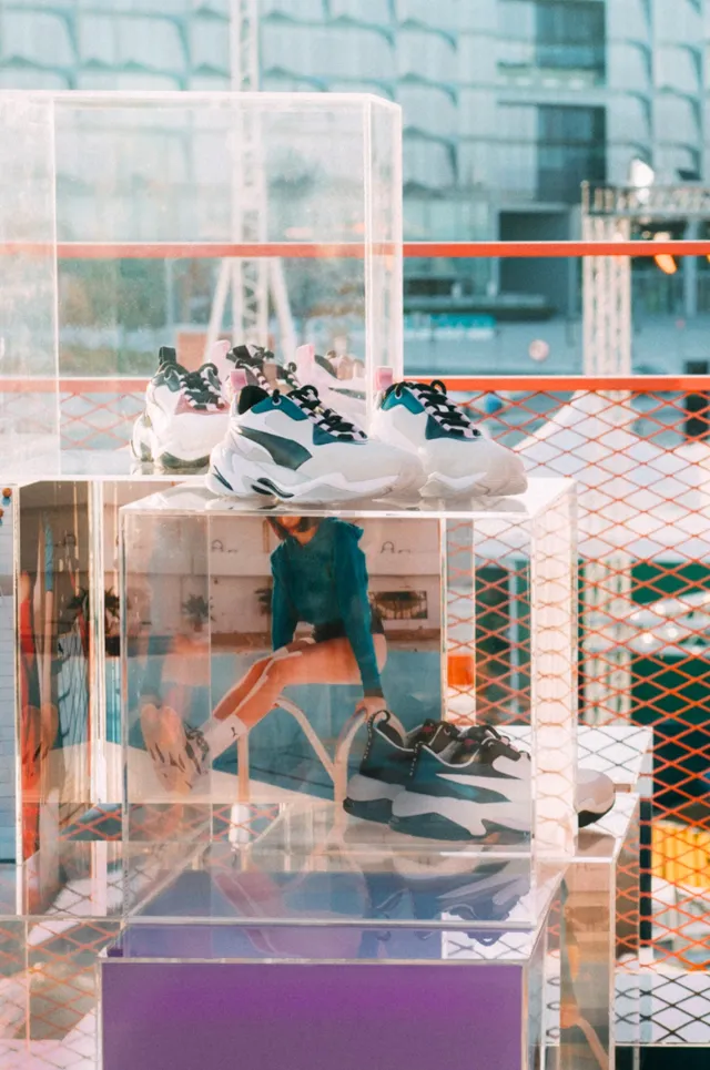 Puma sneakers displayed inside stacked transparent acrylic cases
