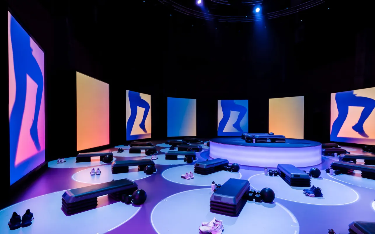 Circular Nike workout stations surrounded by tall animated screens