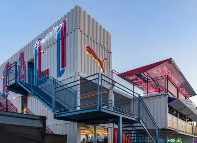 Multi-level Puma pavilion built from stacked shipping containers