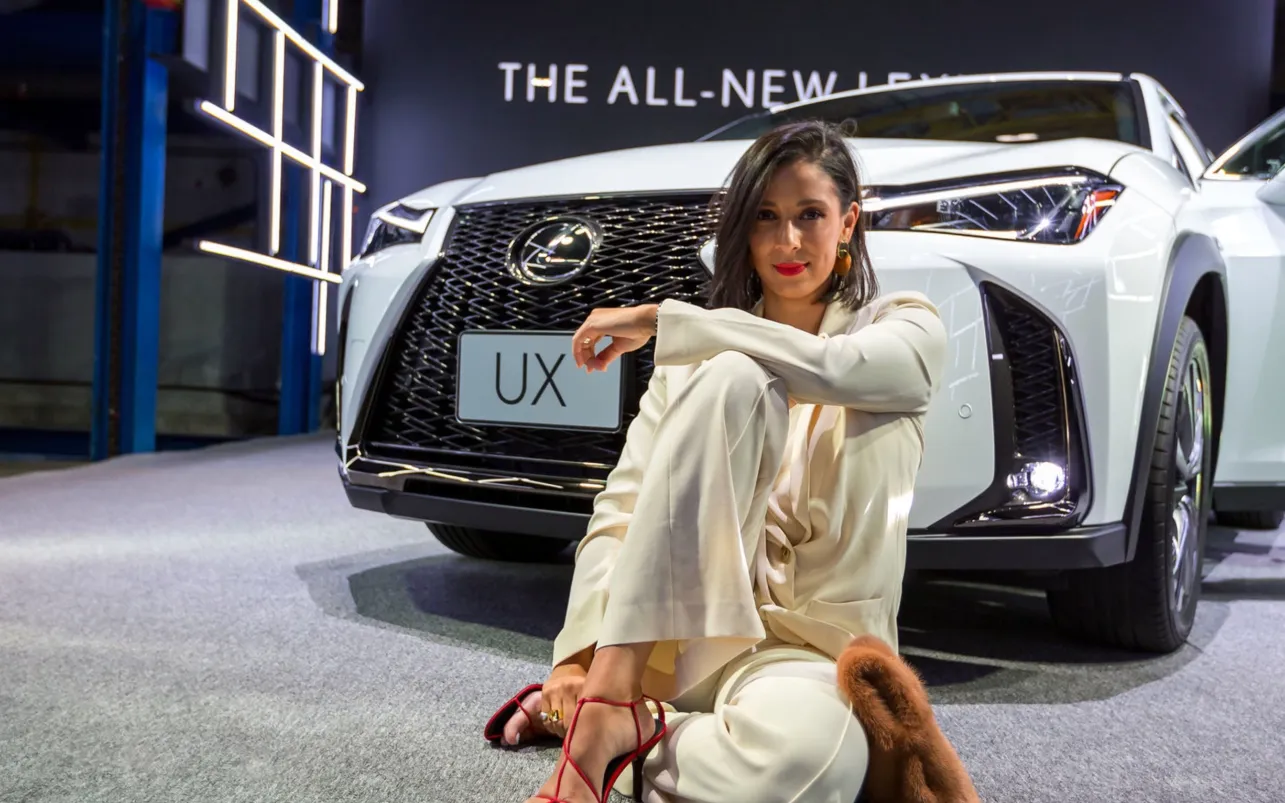 Guest poses beside the white Lexus UX display vehicle