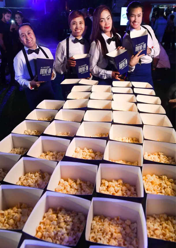 Event staff serve popcorn boxes at the Lexus drive-in cinema
